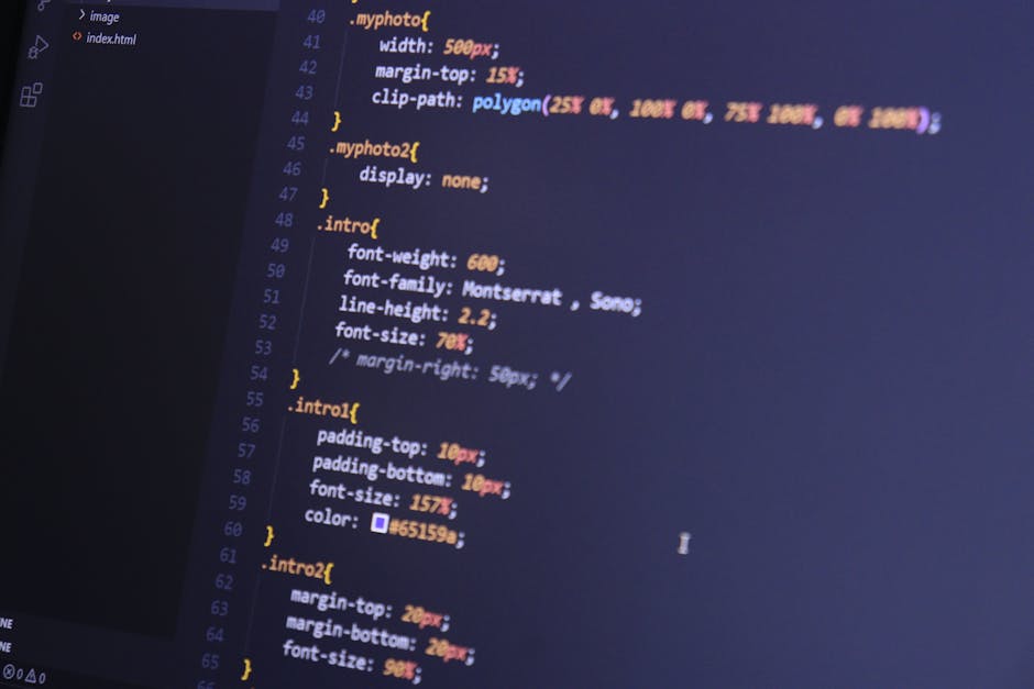 A close-up view of a computer monitor displaying lines of CSS code with various syntax and color-coded elements on a dark background. The code includes font settings such as font weight, family, line 